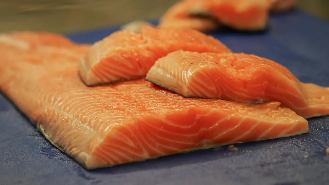 Close-up of fresh salmon fillets with vibrant orange flesh, perfectly sliced and ready for cooking or sushi preparation.