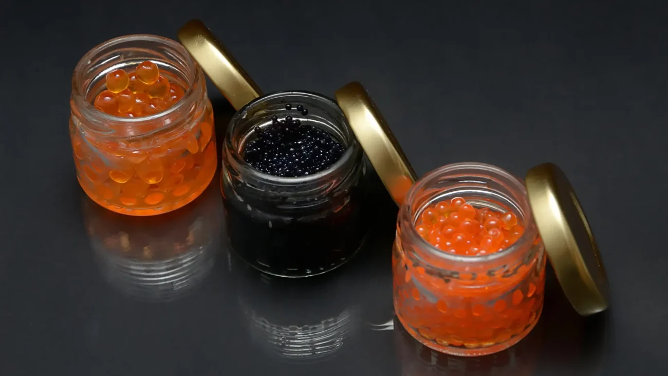 Black and red caviar jars with golden lid